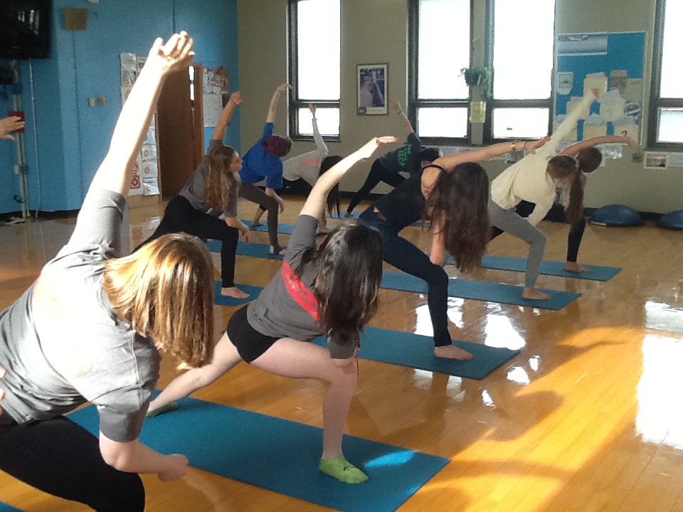 Middle school students practicing yoga in PE class